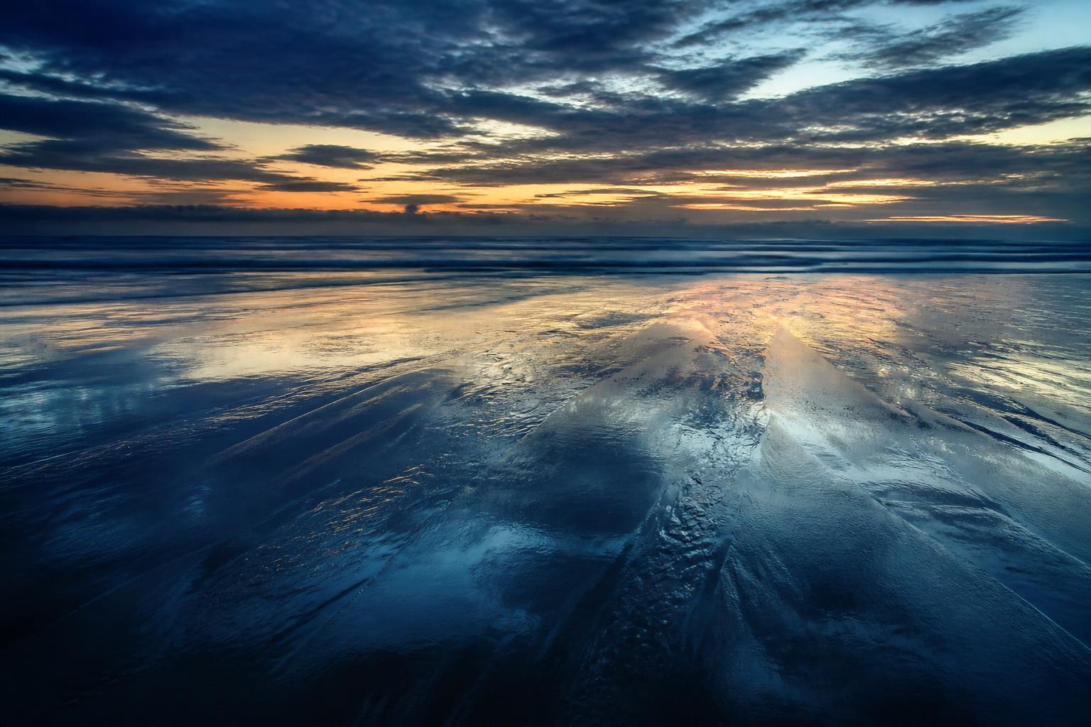 Wet sand reflecting the evening sky